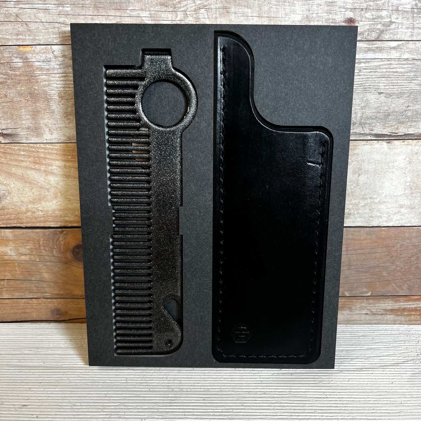 Heircomb Guardian Leather Sheath in Black Finish shown with Executor Comb in Gunmetal Grey finish.